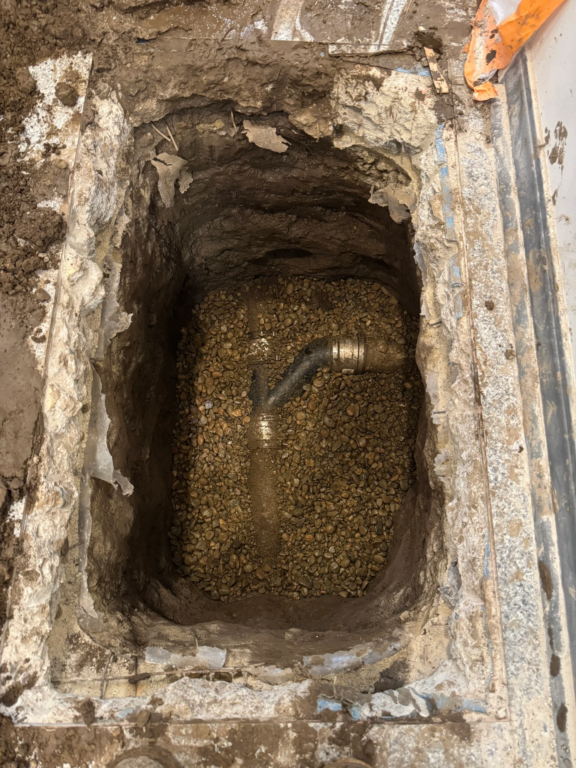 Slab leak excavation showing water damage under foundation